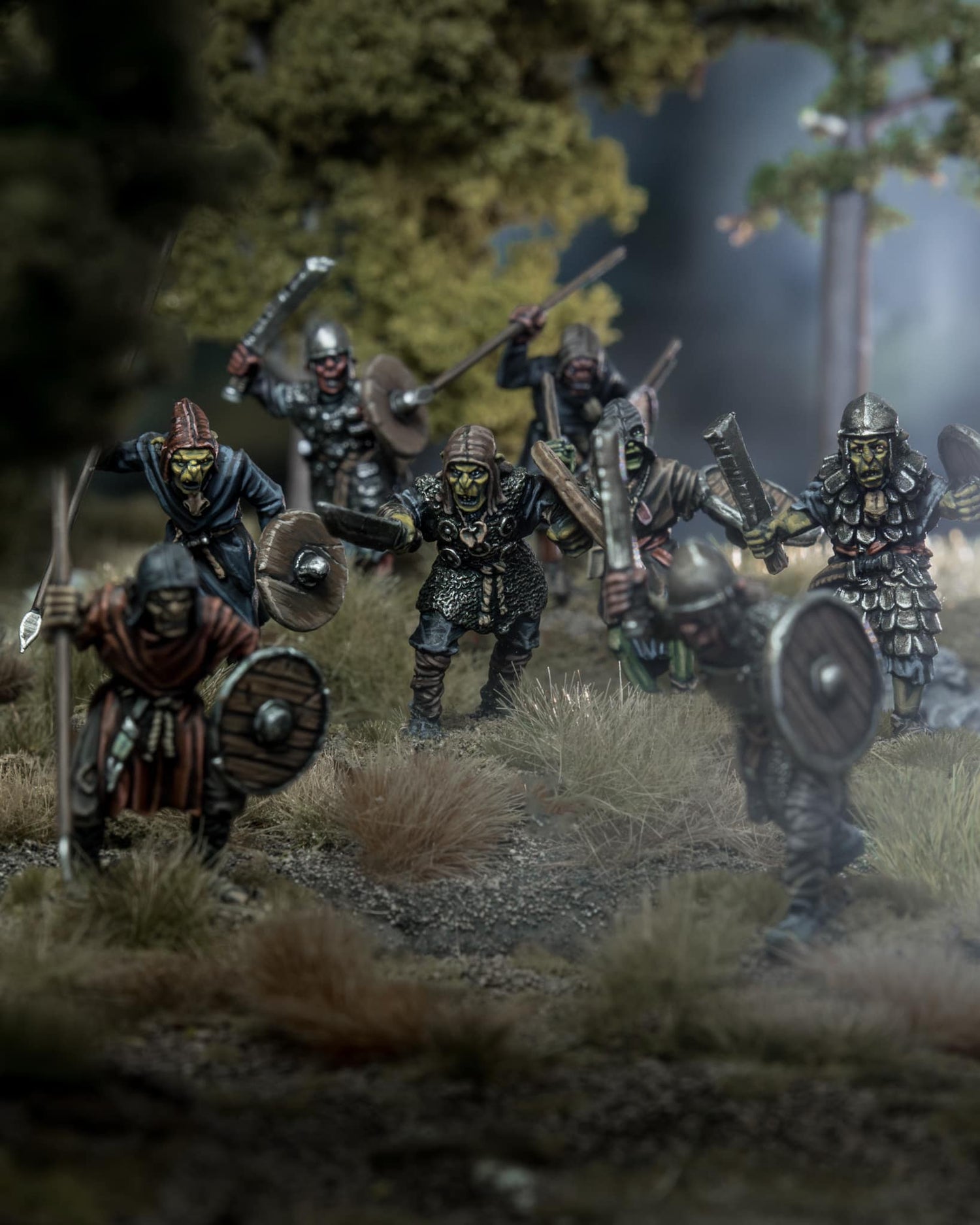 A group of detailed miniature warriors in armor, ready for battle in a forest setting.